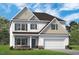 New two-story home featuring attached garage and stone accents, with a manicured lawn and a welcoming entryway at 508 Olivia Crossing Ct # 17, Four Oaks, NC 27524