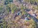 Panoramic aerial view of the home, highlighting its wooded acreage and tranquil neighborhood at 5171 S River Rd, Lillington, NC 27546