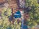 Aerial view of a charming home with a blue roof, surrounded by lush greenery and tall trees at 5171 S River Rd, Lillington, NC 27546