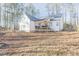 Rear exterior view of a home showcasing a spacious backyard, a deck with stairs, and natural surroundings at 5171 S River Rd, Lillington, NC 27546