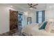 Bright bedroom features a barn door, tray ceilings, fan, and hardwood floors at 5171 S River Rd, Lillington, NC 27546