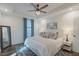 Bright bedroom featuring a ceiling fan, a comfortable bed with decorative pillows, and a full-length mirror at 5171 S River Rd, Lillington, NC 27546