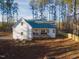 Rear exterior of a bright white home featuring a wooden deck and fenced yard with wooded views at 5171 S River Rd, Lillington, NC 27546
