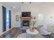 Bright living room with a stone fireplace, large window and wood flooring at 5171 S River Rd, Lillington, NC 27546