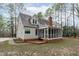 Well-maintained backyard featuring a deck, screened porch, and mature trees for privacy at 5309 Shoreline Ct, Holly Springs, NC 27540