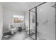 Modern bathroom showcasing a glass shower, a decorative chair, and a window at 5309 Shoreline Ct, Holly Springs, NC 27540