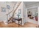 Inviting foyer with hardwood floors, staircase, and view of the living room fireplace at 5309 Shoreline Ct, Holly Springs, NC 27540