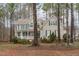 Inviting two-story home with classic architectural details and a covered front porch, nestled among mature trees at 5309 Shoreline Ct, Holly Springs, NC 27540