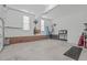 Spacious garage with brick accent wall, work bench, tool storage, and organized storage solutions at 5309 Shoreline Ct, Holly Springs, NC 27540