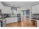 Well-equipped kitchen area with stainless steel appliances, white cabinets, and hardwood floors at 5309 Shoreline Ct, Holly Springs, NC 27540