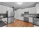 Modern kitchen featuring stainless steel appliances, white cabinets, and hardwood floors at 5309 Shoreline Ct, Holly Springs, NC 27540