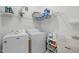 Well-lit laundry room features modern washer and dryer, sink and shelving for storage at 5309 Shoreline Ct, Holly Springs, NC 27540