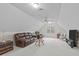 Finished attic space is used as a living room area with multiple couches, seating and TV at 5309 Shoreline Ct, Holly Springs, NC 27540