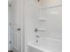 Clean white bathroom with a shower and tub featuring chrome hardware and built-in shelving for optimal storage space at 542 Winding Crk Dr, Lillington, NC 27546