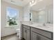 Bathroom with double sinks, grey cabinets, and a large window at 542 Winding Crk Dr, Lillington, NC 27546