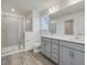 Modern bathroom with dual sinks, gray cabinetry, and a glass-enclosed shower at 542 Winding Crk Dr, Lillington, NC 27546