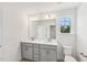 Bright bathroom featuring a double vanity with gray cabinets at 542 Winding Crk Dr, Lillington, NC 27546