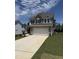 Two-story home with gray siding, a two-car garage, and a concrete driveway surrounded by a green lawn at 542 Winding Crk Dr, Lillington, NC 27546