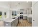 Bright kitchen with a large island featuring a sink, gray cabinets, and stainless steel appliances at 542 Winding Crk Dr, Lillington, NC 27546
