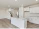 Bright kitchen with an island, white cabinets, and light hardwood floors creates a clean, modern space at 542 Winding Crk Dr, Lillington, NC 27546