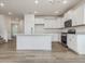 Spacious kitchen featuring white cabinets, a large island, and stainless steel appliances at 542 Winding Crk Dr, Lillington, NC 27546