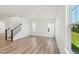 Bright living room with big windows, hardwood floors, and a staircase at 542 Winding Crk Dr, Lillington, NC 27546
