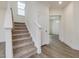 Carpeted staircase provides access to the upper floors of the home near the entryway and downstairs living areas at 542 Winding Crk Dr, Lillington, NC 27546