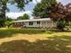 Charming single-story home featuring a well-maintained lawn, manicured shrubs, and a brick accent wall with neutral paint at 6749 Frieden Church Rd, Gibsonville, NC 27249