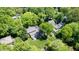 Aerial view of a charming home with a spacious backyard and deck surrounded by lush greenery and mature trees at 826 Warwick Ct, Burlington, NC 27215