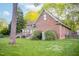 Backyard with a well-maintained lawn, wooden deck, and partial view of the brick home at 826 Warwick Ct, Burlington, NC 27215