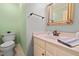Well-lit half bath with neutral vanity, framed mirror, and green accent wall, creating a fresh, clean space at 826 Warwick Ct, Burlington, NC 27215