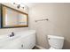 Bathroom featuring a granite vanity, toilet, and a framed mirror at 826 Warwick Ct, Burlington, NC 27215