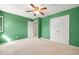 This bedroom features a ceiling fan, green walls, carpeted floor, and closet at 826 Warwick Ct, Burlington, NC 27215