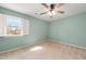 This bedroom features light green walls, carpeted floor, a window, and a ceiling fan at 826 Warwick Ct, Burlington, NC 27215