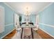 The dining room features a modern table set with white chairs, a chandelier, and light blue walls at 826 Warwick Ct, Burlington, NC 27215