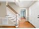 Bright foyer featuring hardwood floors, staircase with white balusters, and a view into a room with blue walls at 826 Warwick Ct, Burlington, NC 27215