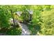 An aerial view of a two-story brick home surrounded by mature trees and a long driveway at 826 Warwick Ct, Burlington, NC 27215
