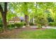 A view of the front of a brick home with large trees in the front yard at 826 Warwick Ct, Burlington, NC 27215