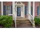 Charming front porch with brick steps and white railing, leading to the front door of the home at 826 Warwick Ct, Burlington, NC 27215