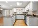 Modern kitchen featuring a large granite island, white cabinets, and stainless steel appliances at 826 Warwick Ct, Burlington, NC 27215