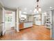 Bright kitchen featuring a spacious island, hardwood floors, white cabinetry, and modern lighting at 826 Warwick Ct, Burlington, NC 27215