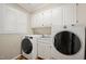 Functional laundry room with modern washer and dryer, cabinets, and a sink at 826 Warwick Ct, Burlington, NC 27215