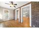 Spacious room with brick accent walls, ceiling fan, and glass doors leading to other parts of the home at 826 Warwick Ct, Burlington, NC 27215