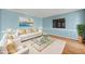 Stylish living room boasts blue walls, hardwood floors, white sofa with throw pillows, and glass top coffee table at 826 Warwick Ct, Burlington, NC 27215
