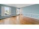 Bright living room with blue walls, white trim, hardwood floors, shuttered windows, and an open doorway at 826 Warwick Ct, Burlington, NC 27215