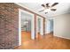 Cozy living room with hardwood floors, brick walls, and open doorway to the modern kitchen at 826 Warwick Ct, Burlington, NC 27215