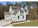 A spacious white home showcasing a two car garage, board and batten siding, and well-manicured lawn at 842 Magnolia Acres Ln, Fuquay Varina, NC 27526