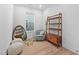 Cozy bedroom featuring natural light, a comfortable chair, modern mirror, and stylish shelving unit at 857 Athens Dr # 102, Raleigh, NC 27606