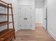 Hallway featuring hardwood floors, stylish doors, and a decorative shelving unit at 857 Athens Dr # 102, Raleigh, NC 27606