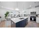 Modern kitchen with white cabinets, stainless steel appliances, quartz counters, and a view of the living room at 857 Athens Dr # 102, Raleigh, NC 27606